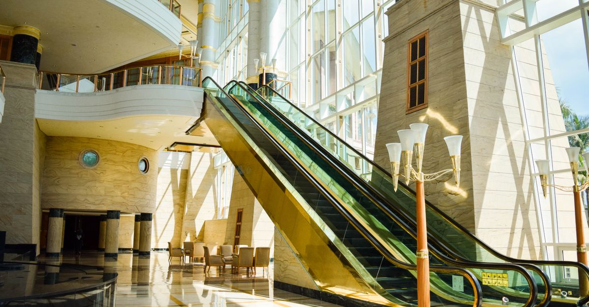 A wide-angle interior view of a modern financial regulatory building lobby with glass walls and soft natural light, muted corporate tones, no visible writing or sign, cinematic and calm atmosphere