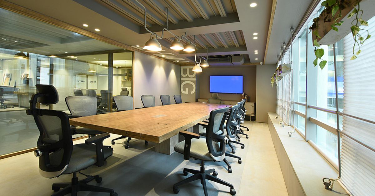 A modern office interior with large digital screens displaying compliance charts, daylight, cinematic angle, no visible detail