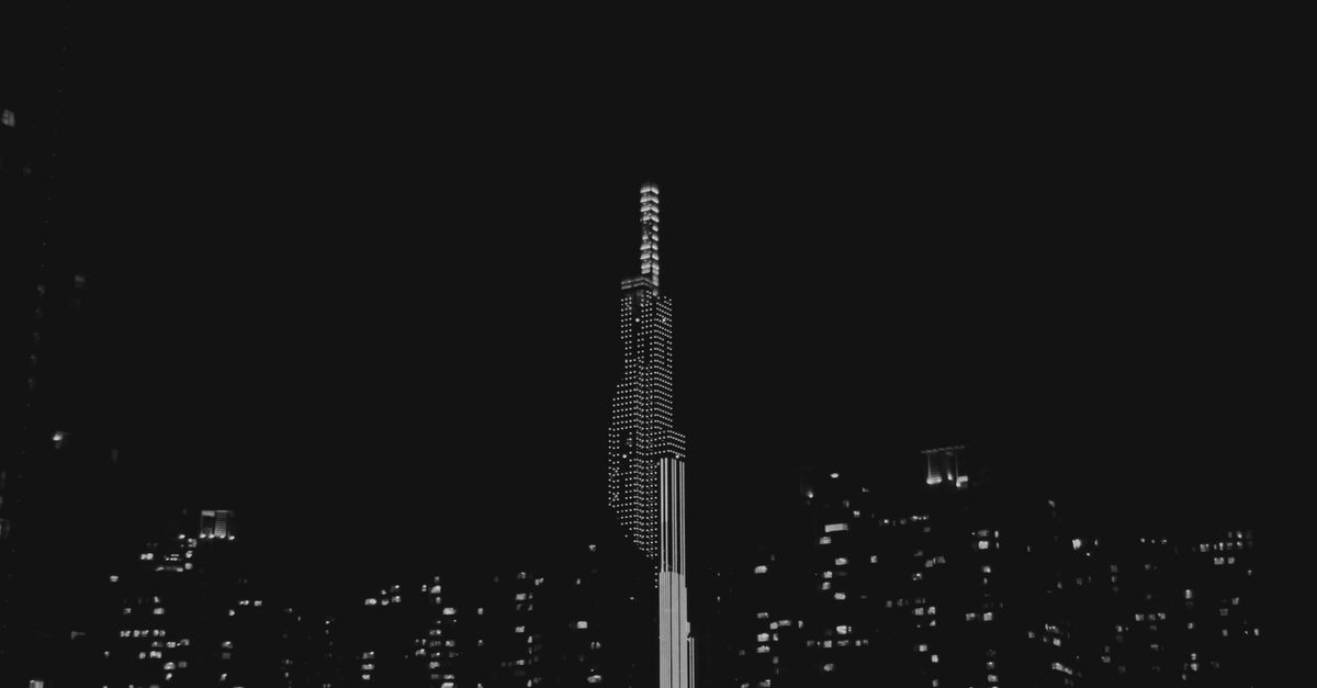A wide-angle nighttime cityscape with glowing smartphone screens visible in a crowd, cinematic muted lighting, focus on urban digital atmosphere, no visible writing or sign, documentary style