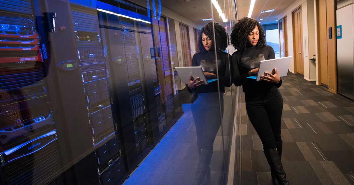 A wide-angle view of a modern data center interior with rows of server racks, cool blue lighting, cables neatly arranged, cinematic depth of field, no visible writing or sign, atmospheric and clean industrial mood