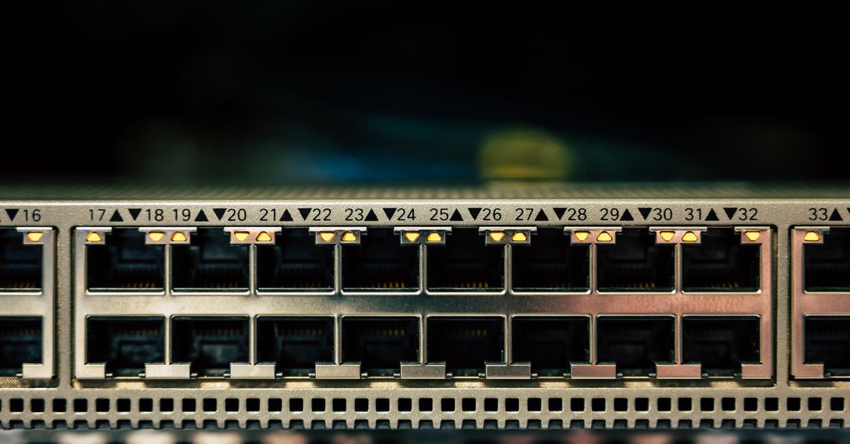 A wide-angle interior view of a modern data center with rows of server racks, cool blue ambient lighting, cables organized neatly, no visible writing or sign, cinematic depth of field